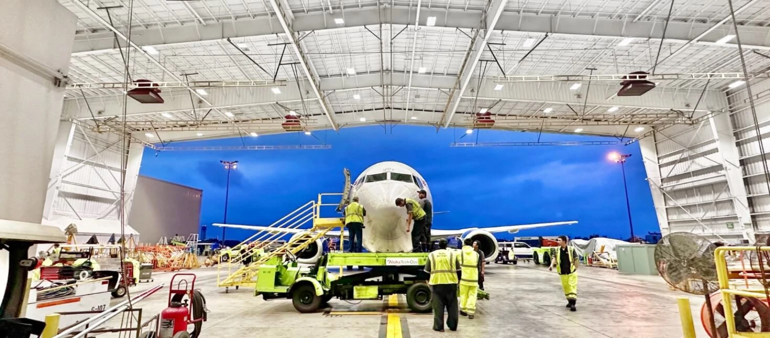 Aloha Tech Ops employees work on a plane parked in the Maintenance hangar.