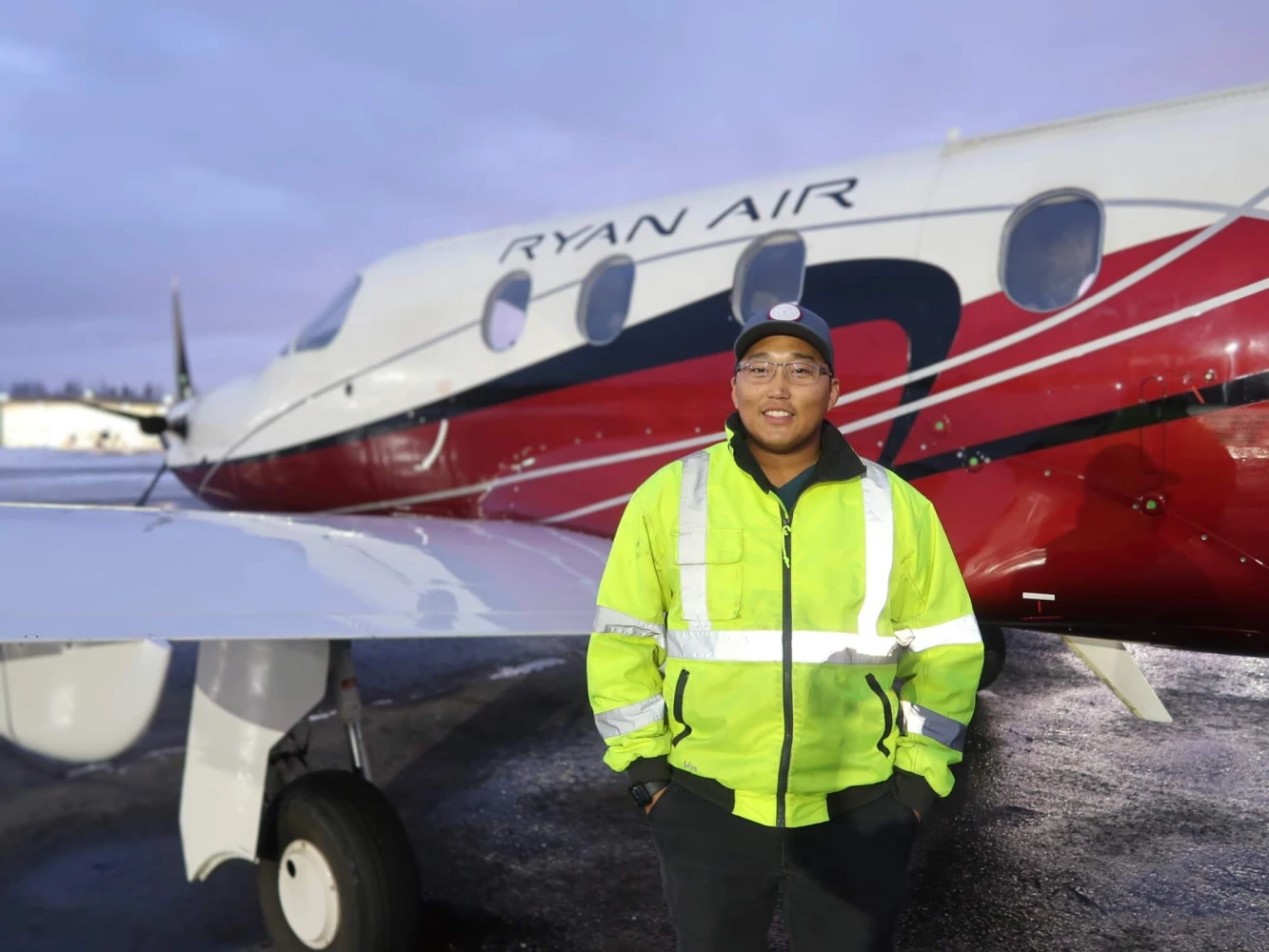 A Ryan Air employee posing in front of a Ryan Air plane.