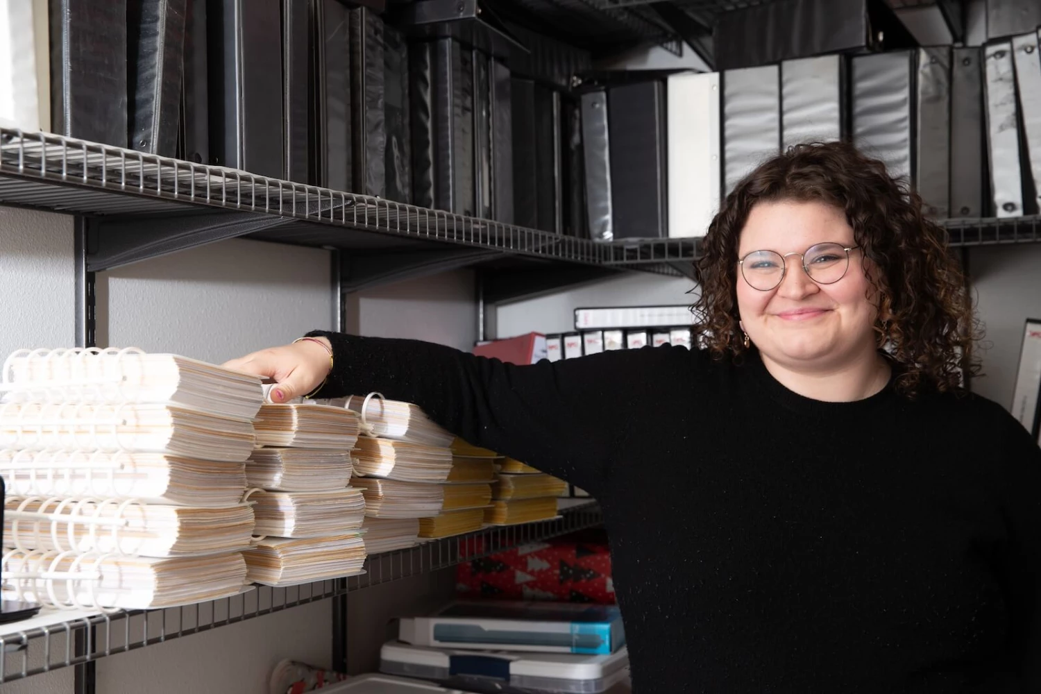 A Saltchuk Aviation Shared Services employee standing in a room surrounded by aviation publication books.