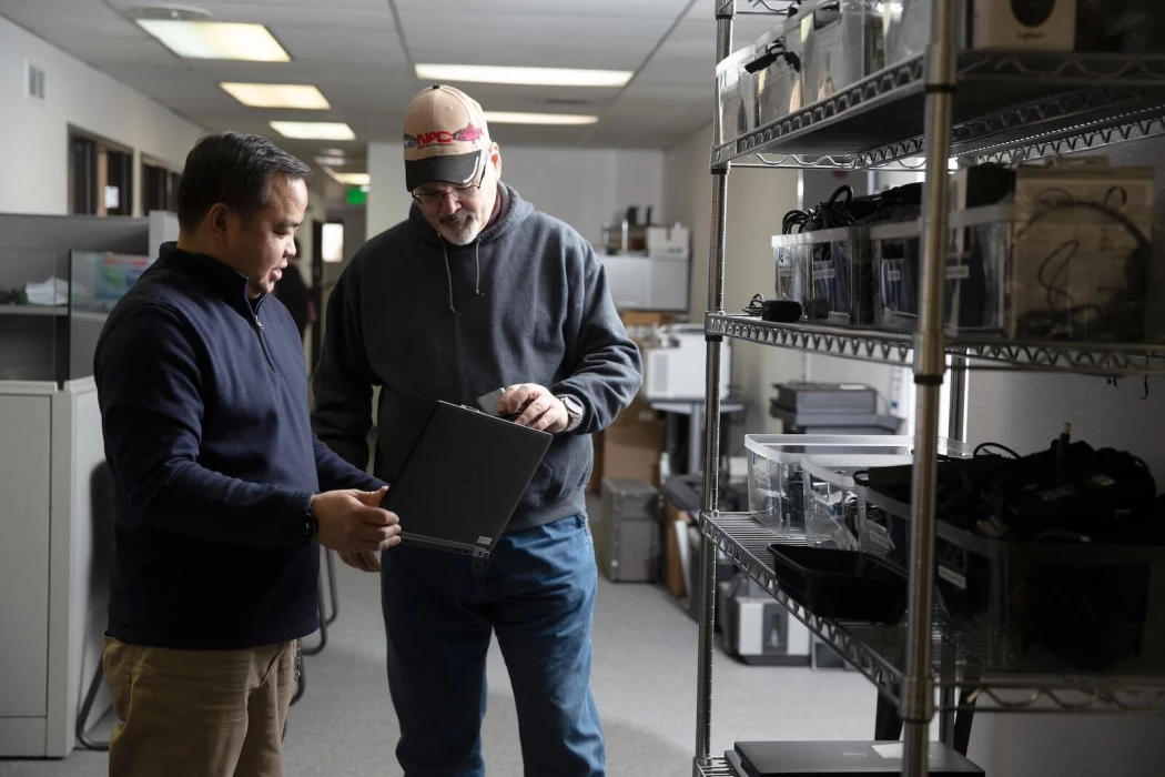 Two Saltchuk Aviation Shared Services IT employees looking at a laptop together.