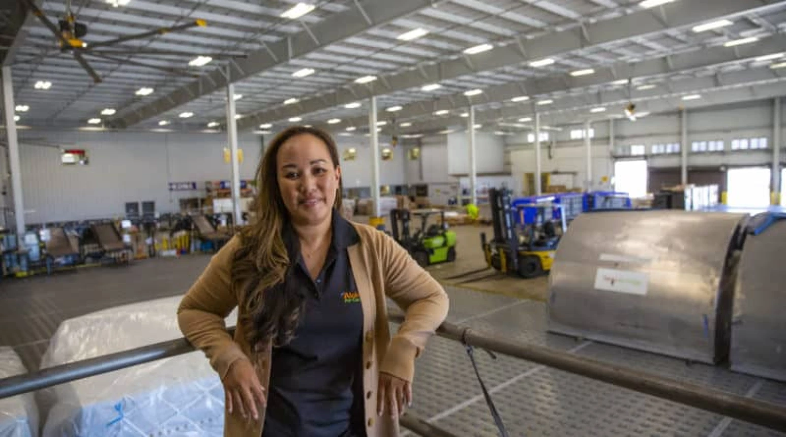 Photo of Aloha Air Cargo employee Coleen Kaneshiro standing in a cargo warehouse.