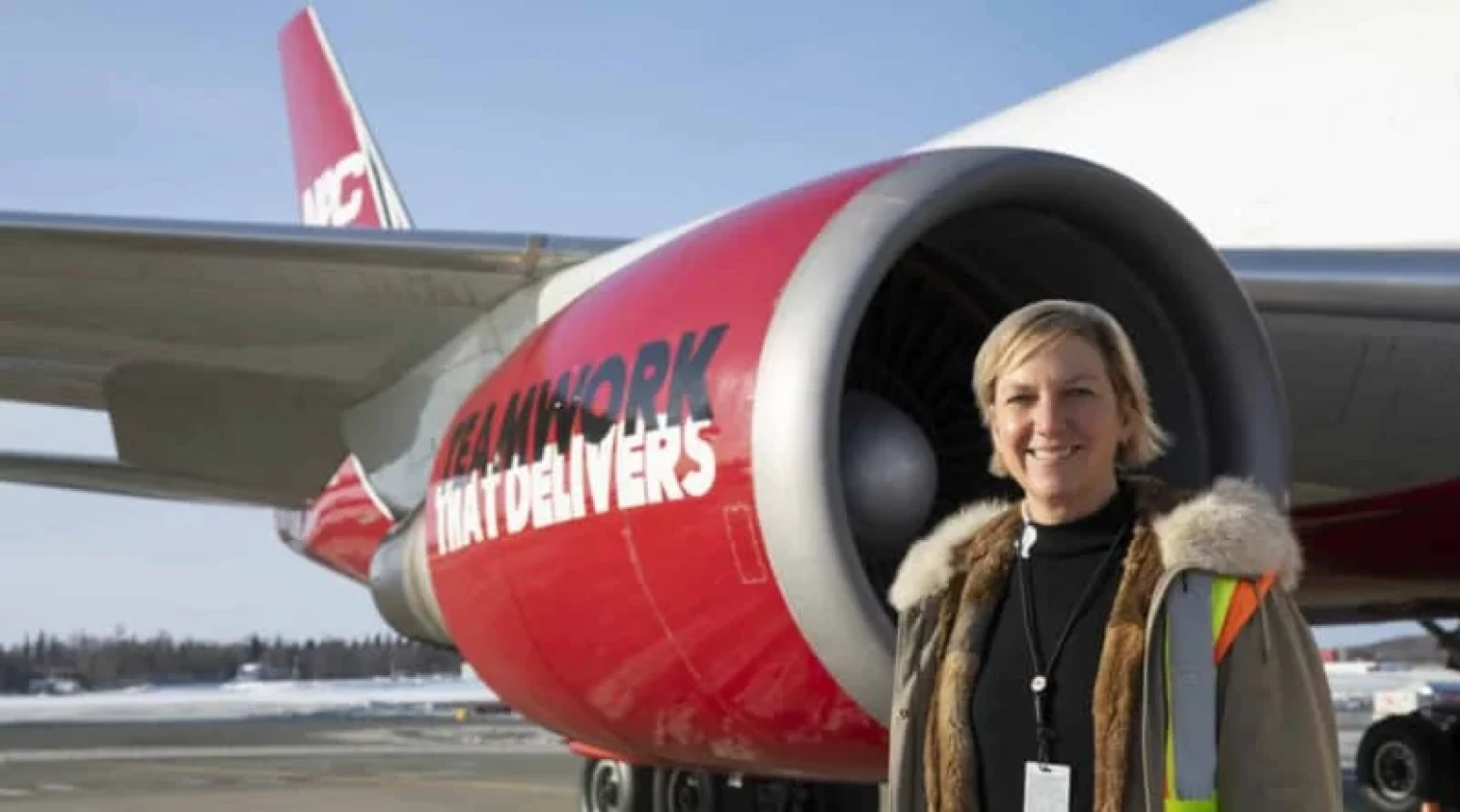 Photo of President & CEO Betsy Seaton standing in front of a NAC plane.